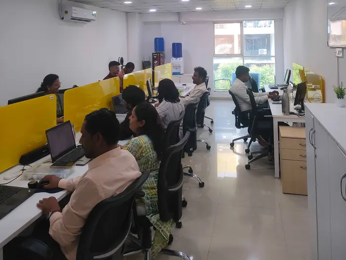 Barquecon Technologies team collaborating at their workstations in the office